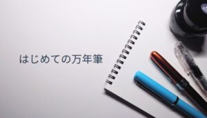 開いたメモ帳の上にプロシオン・プレジール・プレピーの3本の万年筆とインクボトルが並ぶ