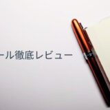 メモ帳のカバーに挿されたプラチナ万年筆プレジール。ノバオレンジのクリップが映える実用的な使用シーン