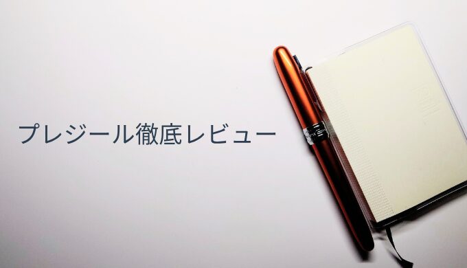 メモ帳のカバーに挿されたプラチナ万年筆プレジール。ノバオレンジのクリップが映える実用的な使用シーン