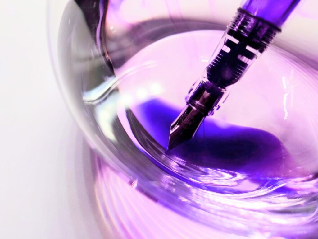 透明ガラス容器に浸けて洗浄している万年筆のペン先