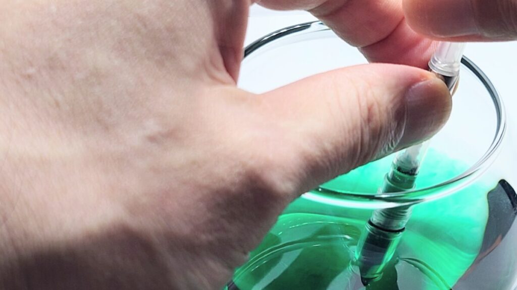 コンバーター式万年筆で水を吸入・排出している洗浄作業の様子