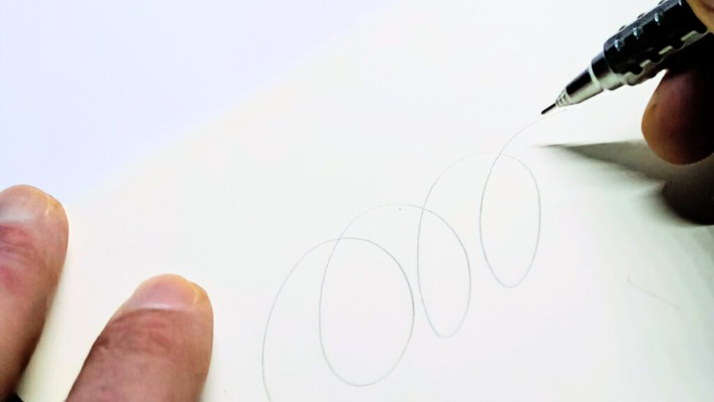 オレンズATでくるくると線を描いた手元の構図。白背景で筆記感を自然に表現。