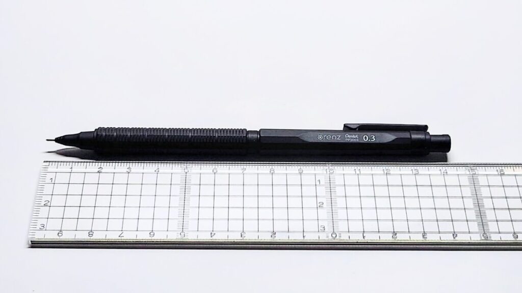 オレンズネロを定規と並べた斜めアングルの構図。白背景でサイズ感と高級感を表現。