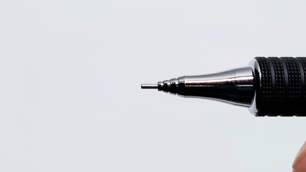 オレンズ メタルグリップのペン先アップ。1回ノックした後、金属パイプが芯を覆った状態で筆記準備が整っている様子。