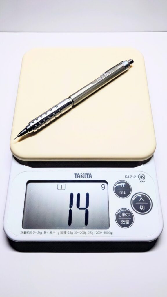 オレンズATを計量器に載せて計測した画像。実測値は14gで、記事では約15gとして紹介している。